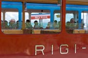 ARCHIV - ZUR BILANZMEDIENKONFERENZ DER RIGI BAHNEN AG STELLEN WIR IHNEN FOLGENDES BILDMATERIAL ZUR VERFUEGUNG, AM FREITAG, 5. APRIL 2019 - Detail view of the red Rigi Railway in into the blue railway with travellers Rigi Kulm stop on Mount Rigi, Switzerland, on July 18, 2016. (KEYSTONE/Gaetan Bally)Detailsansicht der roten Rigi-Bahn mit dem Schriftzug "Rigi" mit Blick auf Reisende in der blauen Bahn bei der Station Rigi Kulm am 18. Juli 2016 auf der Rigi. (KEYSTONE/Gaetan Bally)