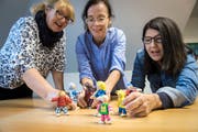 Familienhelferin Monika Hauser, Schulberaterin Ulrike Wolf und Coach Loredana Pachioli spielen mit Figuren Familiensituationen nach. (Bild: Reto Martin)