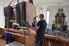 Auf der Empore angekommen, wird die Orgel manuell an den endgültigen Standort platziert.