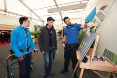 Rainer Henggele mit Sohn Jonas stellen dem Polizisten Marcel Müller am Stand der Zuger Polizei Fragen über den Verkehr. (Bild: Roger Zbinden (Zug, 20. Oktober 2018))