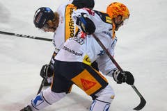 Johnny Kneubühler (Ambri, links), kämpft mit Zugs David McIntyre um den Puck. (Bild: Alessandro Crinari/Keystone)
