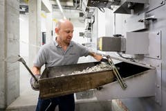 Paul Gisler nimmt drei Stunden nach dem Start des Kremationsprozesses die Überreste aus dem Ofen. (Bild: Philipp Schmidli, Luzern, 16. Oktober 2018)