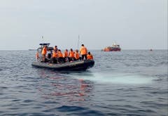 Rettungskräfte bei der Absturzstelle. (Bild: AP Photo/Achmad Ibrahim)