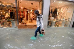 Eine Frau schreitet durch eine überflutete Strasse in Venedig. Gemäss den Behörden stehen 70 Prozent des historischen Zentrums der Stadt unter Wasser. (Bild: Andrea Merola/Keystone (29. Oktober 2019))