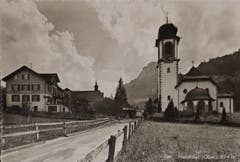Die Dorfstrasse von Melchtal Anfang der Vierzigerjahre mit der Bäckerei Huwyler und der Wirtschaft sowie der Wallfahrtskirche auf der anderen Strassenseite. (Bild: PD)