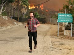 Anwohner versuchen ihre Häuser zu retten. (Bild: Reed Saxon/AP (Malibu, 9. November 2018))