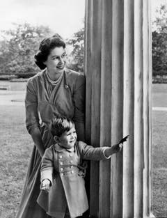 Königin Elizabeth II. schaut mit dem zweijährigen Prinz Charles hinter einer Säule hervor, aufgenommen am 20. Oktober 1950 auf dem Grundstück von Clarence House in London. (Bild: Archiv KEYSTONE/Str)