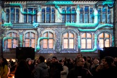 Besucher verfolgen die Lichtprojektionen anlässlich des Weihnachtsfestivals im Landesmuseum in Zürich. (KEYSTONE/Ennio Leanza, 15. November 2018)
