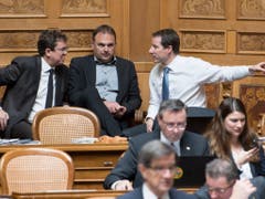 Diskussion in der SVP-Fraktion während der Budgetdebatte im Nationalrat: Parteipräsident Albert Rösti (BE), Marcel Dettling (SZ) und der Zuger Thomas Aeschi (von links) (Bild: KEYSTONE/PETER SCHNEIDER)
