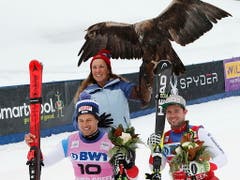 Sieger Beat Feuz (rechts) und der zweitklassierte Teamkollege Mauro Caviezel posieren bei der Siegerehrung mit einem Adler (Bild: KEYSTONE/EPA/JOHN G. MABANGLO)