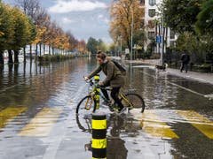 «Wasserrad Fahren» auf einer überschwemmten Strasse in Locarno. (Bild: KEYSTONE/TI-PRESS/ALESSANDRO CRINARI)