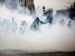 Aktivisten der «Gelbwesten»-Bewegung haben ihre Proteste gegen die Politik von Staatschef Emmanuel Macron in Paris fortgesetzt. Dabei kam es zu Ausschreitungen mit der Polizei, die auch Tränengas einsetzte. (Bild: KEYSTONE/AP/KAMIL ZIHNIOGLU)
