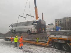 Langsam senkt der Car den Reisebus auf einen Tieflader zum Abtransport. (Bild: Monika Freund, Keystone-SDA)
