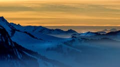Nebelverhangene Hügellandschaft im Toggenburg mit einem brennenden Himmel im Hintergrund. (Bild: Reto Schläpfer)