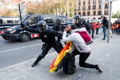 Ein Polizist und ein pro-separatistischer Demonstrant treffen in der katalanischen Metropole Barcelona aufeinander. (Bild: Alex Caparros/Getty (Barcelona, 21. Dezember 2018))