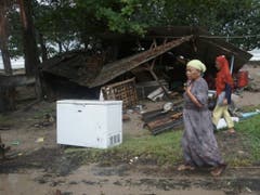 Bis zu 20 Meter hohe Wellen: Bewohner vor ihren vom Tsunami zerstörten Häusern in Carita in Indonesien. (Bild: KEYSTONE/AP/DIAN TRIYULI HANDOKO)