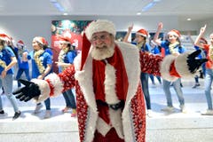 Ein als Weihnachtsmann verkleideter Mann aus Armenien tanzt mit libanesischen und armenischen Kindern am Rafik Hariri International Airport in Beirut. (Bild: Wael Hamzeh/EPA (Beirut, 25. Dezember 2018))