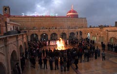 Irakische Christen versammeln sich um ein Feuer während der Weihnachtsabend-Prozession in der Nähe von Mosul. (Bild: EPA/AMMAR SALIH, 24. Dezember 2018)