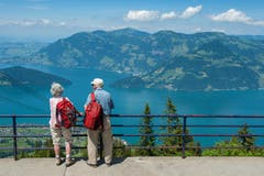 Zwei ältere Menschen geniessen die Aussicht von der Klewenalp auf den Vierwaldstättersee. (Bild: Boris Bürgisser, 28. Juni 2016)