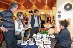 Walter Steiner (v.l.) mit Liliane und Matthias Rohrbach am Stand der Scherenschnittkünstlerin Marianne Schönenberger. (Bild: Adi Lippuner)
