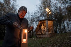 Alois Muri, Gemeindepräsident von Gisikon, zündet eine Laterne an. (Bild: Corinne Glanzmann; 30. November 2018)