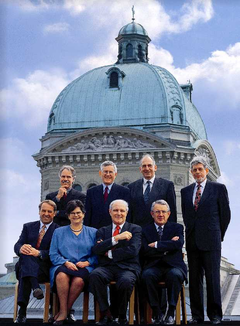1998, Bild 2: (von links): Adolf Ogi, Moritz Leuenberger, Ruth Dreifuss, Kaspar Villiger, Bundespräsident Flavio Cotti, Pascal Couchepin, Arnold Koller, Bundeskanzler François Couchepin.