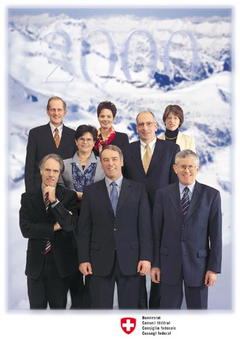 2000 (von links nach rechts, von hinten nach vorne): Joseph Deiss, Ruth Metzler, Bundeskanzlerin Annemarie Huber-Hotz, Ruth Dreifuss, Pascal Couchepin, Moritz Leuenberger, Bundespräsident Adolf Ogi, Kaspar Villiger.