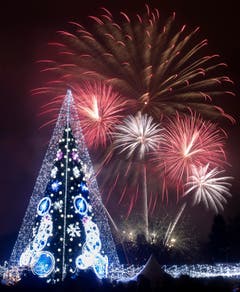 Litauen: Feuerwerk mit beleuchtetem Weihnachtsbaum im Vordergrund in Vilnius. (Bild: Keystone/AP Photo/Mindaugas Kulbis)