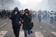 Ein Demonstrant und eine Demonstrantin auf der Flucht. (Bild: Rafael Yaghobzadeh/AP Photo (Paris, 08.12.2018))