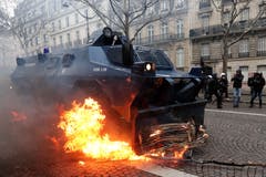 Ein Polizeifahrzeug räumt eine brennende Barrikade weg. (Bild: Ian Langsdon/EPA (Paris, 08.12.2018))