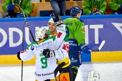 Die Zuger Garrett Roe (US) und Thomas Thiry, v.l. jubeln nach der 0:1 Führung und der Davoser Tino Kessler verlässt enttäuscht das Eis. (Bild: KEYSTONE/Juergen Staiger, 9. Dezember 2018)