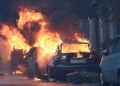 Autos auf den Strassen Mailands brennen lichterloh, nachdem die italienische Polizei und die Demonstranten aneinander gerieten. (Bild: DANIEL DAL ZENNARO)
