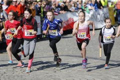 kinder und Erwachsene laufen durch die Zuger Altstadt, beobachtet von Hunderten Zuschauern. (Bild: Stefan Kaiser (Zuger Zeitung))