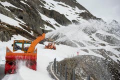 Bei trübem Wetter fräsen sich die Arbeiter mit ihren Maschinen durch die Schneemassen. (Bild: Keystone / Urs Flüeler)