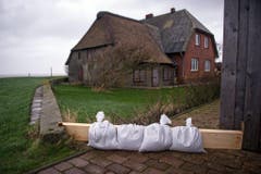 Auf der Hallig Langeness in Deutschland sollen Sandsäcke ein Wohnhaus schützen. (Bild: Keystone)