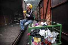 Ricupero Walter, Mitarbeiter von Texaid, beim Entsorgen von Gegenständen aus einem Bahnwagen, die nicht in die Kleidersammlung gehören. (Bild: Eveline Beerkircher/Neue LZ)