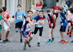 kinder und Erwachsene laufen durch die Zuger Altstadt, beobachtet von Hunderten Zuschauern. (Bild: Stefan Kaiser (Zuger Zeitung))