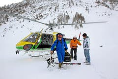 Vater Alois Baumann hilft seinem Sohn Daniel, welcher mit dem Helikopter eingeflogen wurde, das Material auszuladen. (Bild: Philipp Schmidli/Neue LZ)