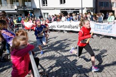 kinder und Erwachsene laufen durch die Zuger Altstadt, beobachtet von Hunderten Zuschauern. (Bild: Stefan Kaiser (Zuger Zeitung))