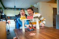 Melanie und ihr Vater Titus spielen Uno. Damit Melanie mitspielen kann, hat sie eine spezielle Vorrichtung für die Karten. (Bild: Boris Bürgisser (Neue LZ))