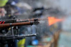 Eine Stichflamme aus einem Gewehr eines Rütlischützen. (Bild: Keystone)
