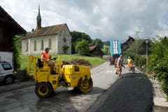 Tatkräftig sanieren diese Männer die Strasse im Dörfli. (Bild: Dominik Wunderli (Neue LZ))