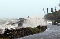 Wellen peitschen gegen die Küstenstrasse im nordirischen Antrim. (Bild: Keystone)