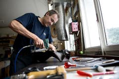 Mitarbeiter Bruno Egli bezieht das Sattelgestell mit Leder. (Bild: Corinne Glanzmann / Neue LZ)