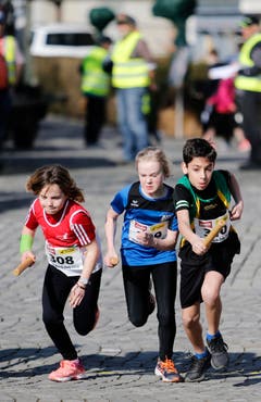 kinder und Erwachsene laufen durch die Zuger Altstadt, beobachtet von Hunderten Zuschauern. (Bild: Stefan Kaiser (Zuger Zeitung))