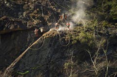 Am Freitag bohrten Felsarbeiter Löcher für die Sprengung am Samstag. Das instabile Gestein wird bis zur grünen Markierung (unten links) entfernt. (Bild: Keystone)