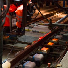 Die letzten der 380 000 Einzelblock-Schwellen im Gotthard Basistunnel sind Goldfarben und werden am Freitag, 31. Oktober 2014, bei Biasca in Beton eingegossen. (Bild: SIGI TISCHLER)