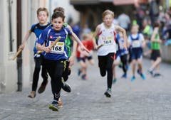 kinder und Erwachsene laufen durch die Zuger Altstadt, beobachtet von Hunderten Zuschauern. (Bild: Stefan Kaiser (Zuger Zeitung))