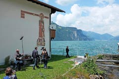 Diese Szene ist nur für die Zeitung und Online, denn: Diese Szene hat es nicht in den Danioth-Film geschafft. Hans Jakob Burkhardt (vorne, beim See) wuchs an der Isleten auf und musste mit dem Schiff zur Schule nach Flüelen fahren. Ich wollte ihn ursprünglich am Danioth-Sgraffito der Heiligen Barbara bei der Sprengstofffabrik Cheddite vorbeilaufen lassen. Aus Zeitgründen mussten wir diese Szene dann allerdings herausschneiden. Immerhin kommt das Sgraffito jetzt wenigstens in der «Neuen Urner Zeitung» und auf Urnerzeitung.ch wieder einmal zur Geltung. (Bild: Felice Zenoni)