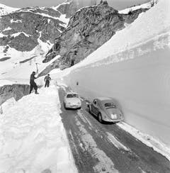 Zwei Arbeiter sind im April 1960 mit der Schneeräumung der Simplonpassstrasse beschäftigt. (Bild: Keystone)